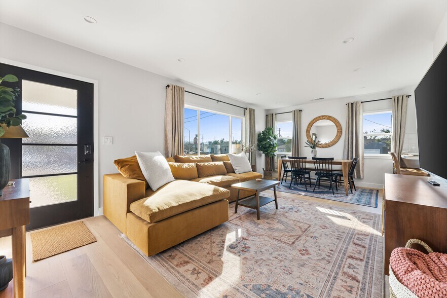 Living room with West Elm furniture, natural sunlight, and large TV flatscreen. - 1823 N Ditman Ave
