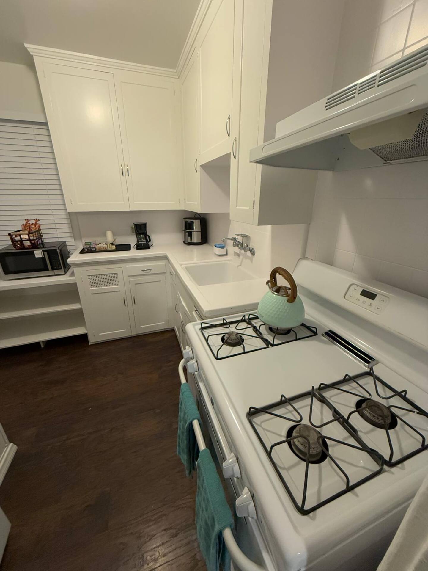 Fully equipped kitchen with gas stove, oven, microwave, coffee maker, and refrigerator. - 312 Rosecrans St