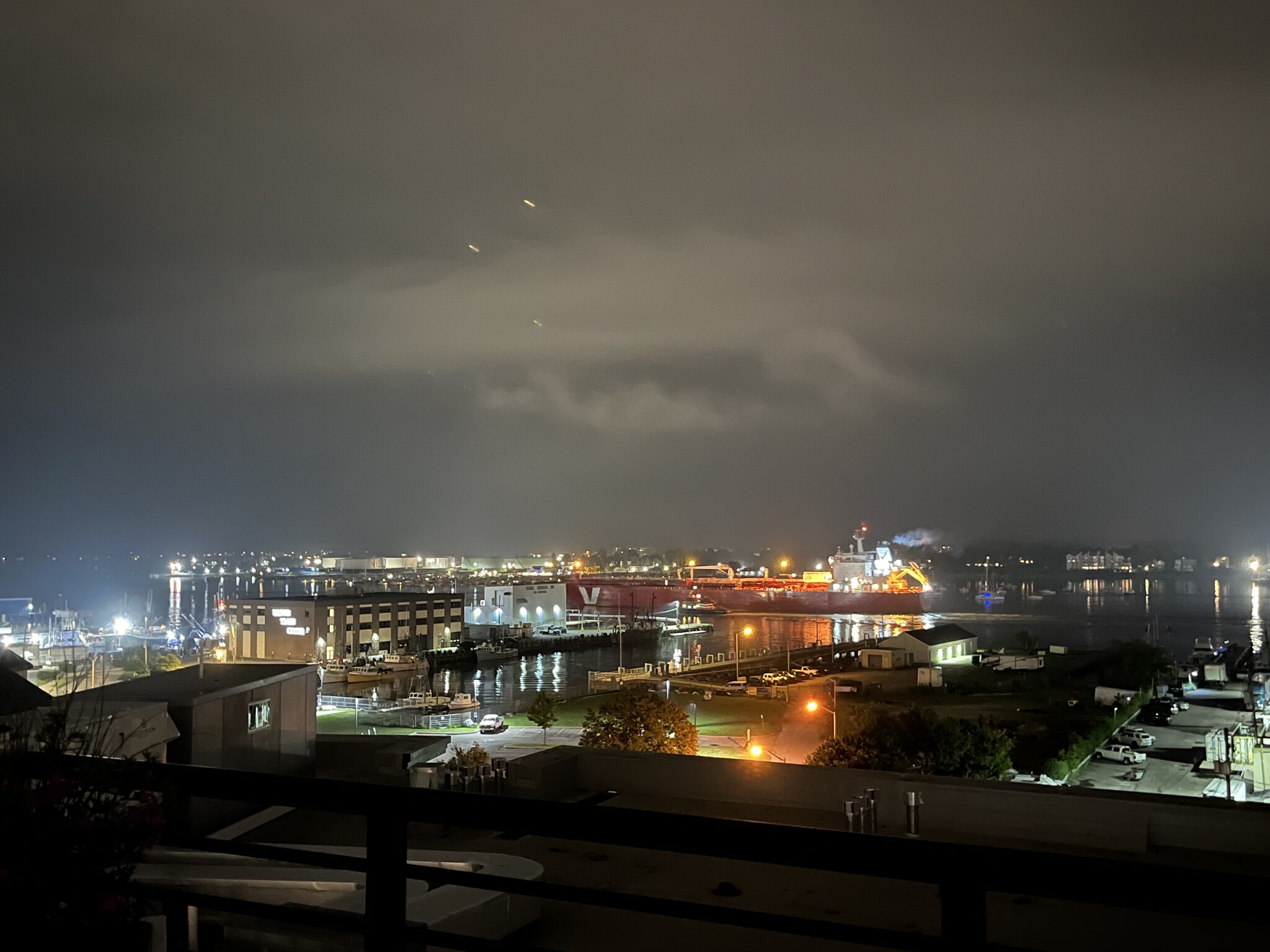 A freighter ship passing by at night. - 387 Commercial St