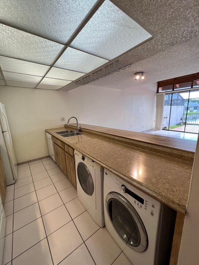 Fully equipped kitchen with washer and dryer hidden below counter - 1424 SW 131st Place Cir E