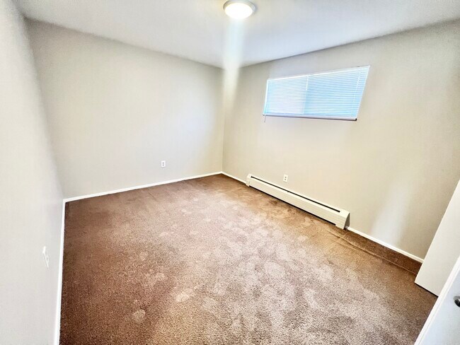 Experience comfort in this well-lit, cozy bedroom designed for relaxation. - Westland Apartments