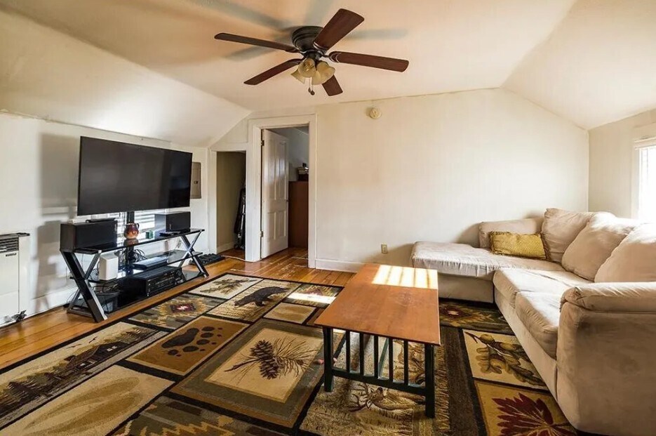 Living with original hardwood floors, ceiling fan, windows filled with natural light - 521 Bay St