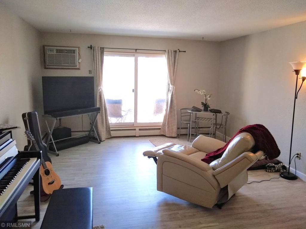 Living room with balcony looking over green space and courtyard - 7414 W 22nd St