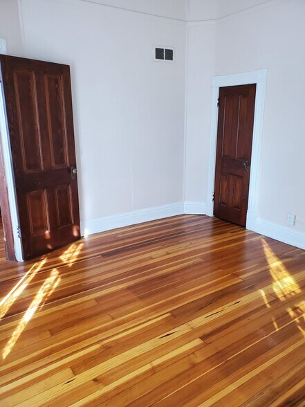 Front bedroom with view of opened entry door and closet door - 607 Harrison Ave