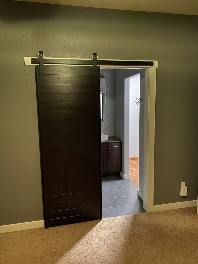 barn door seperates master bedroom from master bath and walk in closet - 20637 Honeysuckle Ln