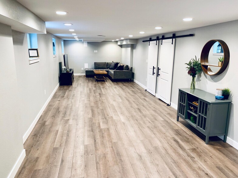 Spacious downstairs living area featuring new laminate wood flooring. - 1447 Osceola St