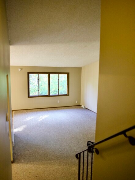 View of living room from upstairs. Lots of space! High ceilings. - 8016 Zane Ave N