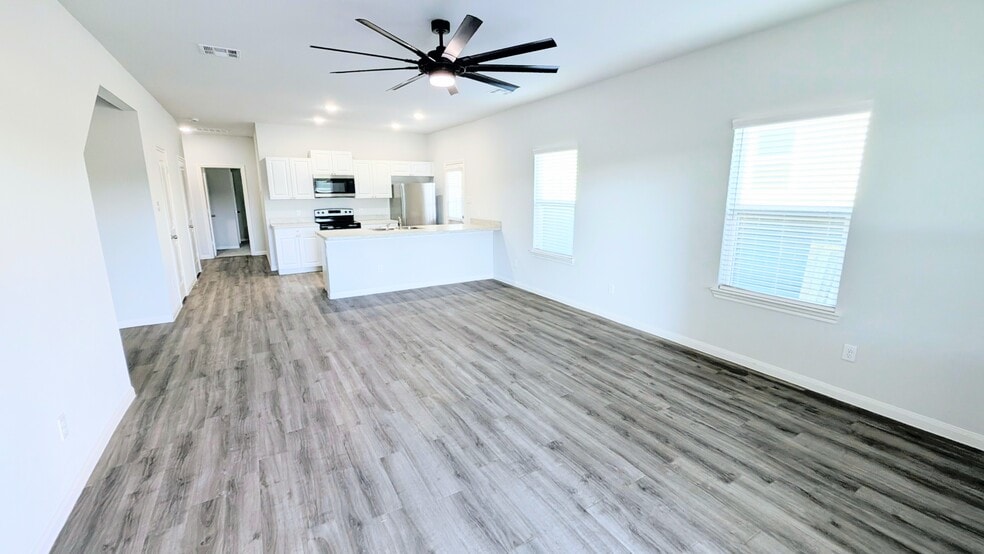This light and bright living space has LVP flooring for easy cleanup. - 13218 HP Johnson St