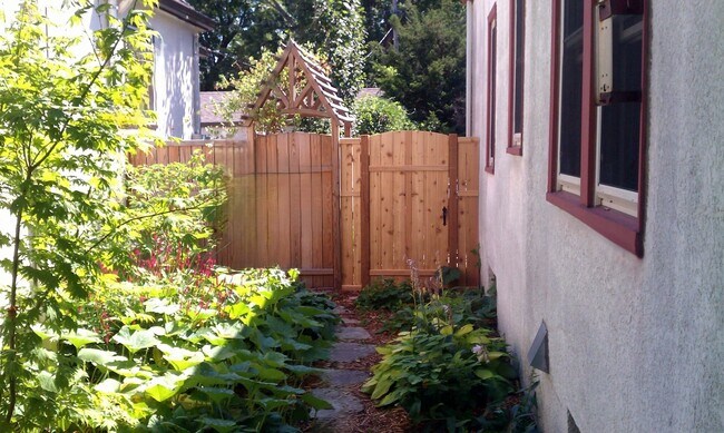 Landscaped side yard and pathway leading to fenced in backyard. - 2923 Arthur St NE