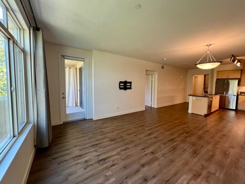 Living room looking towards the balcony (left) and primary bedroom (right) - 8355 Station Village Ln