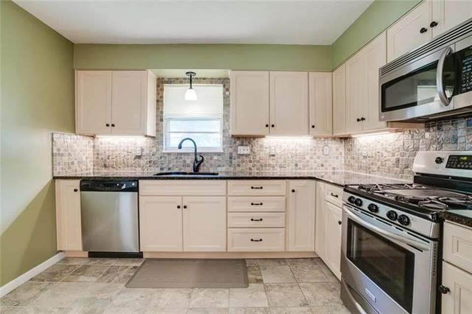 Kitchen with stainless steel appliances, soft close cabinets. New backsplash, dishwasher, and garbage disposal. - 7416 N. Central St.