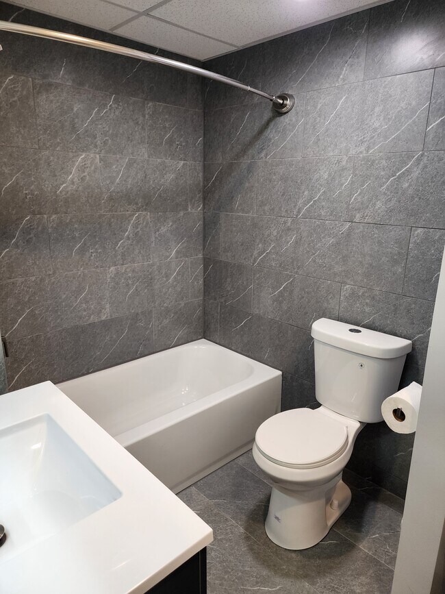 Newly renovated bathroom with floor to ceiling tile and all new fixtures - 100 Manning Pl