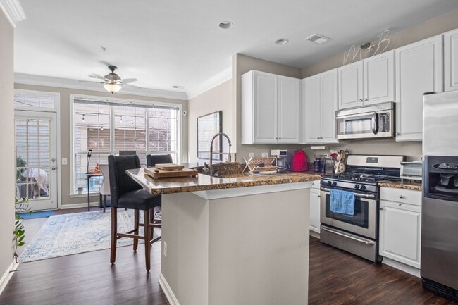 Building Photo - This inviting two-level townhome offers comfort and style, featuring gleaming hardwood floors on ...