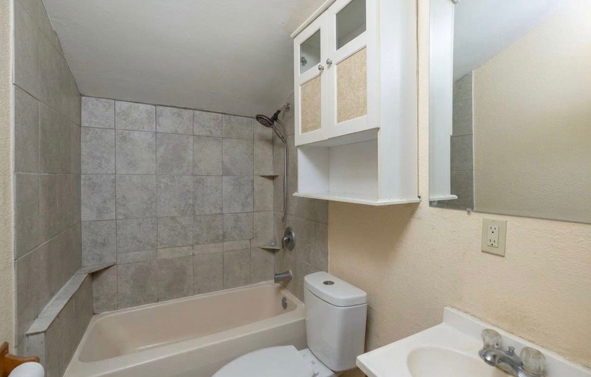 Bathroom with shower/bathtub, sink, cupboard space and toilet - 1126 7th Ave SE